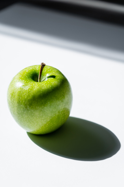 close up of green apple with shadow on white - Zdjęcie, obraz