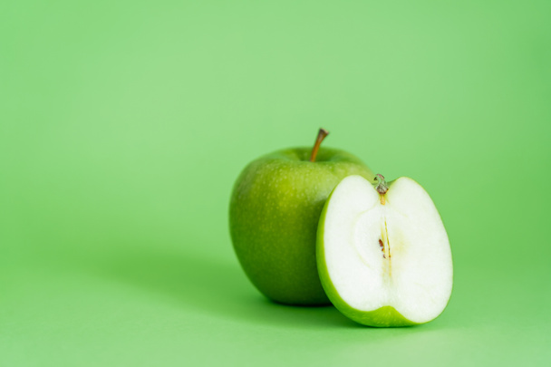 organic and fresh apples on green background - 写真・画像