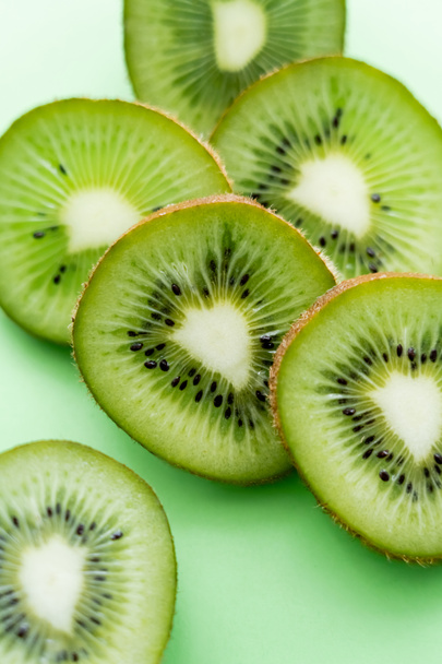 close up view of sliced and fresh kiwi on green - Foto, afbeelding