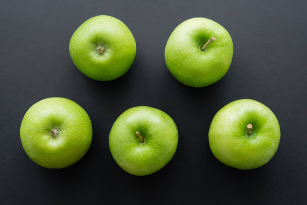 flat lay of fresh and green apples on black  - 写真・画像