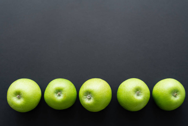 top view of fresh and green apples in row on black  - Foto, Imagem