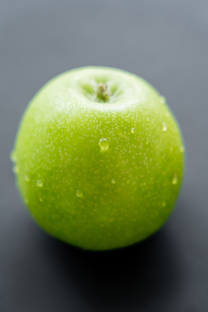close up view of green and fresh apple with water drops on black  - Foto, Imagen