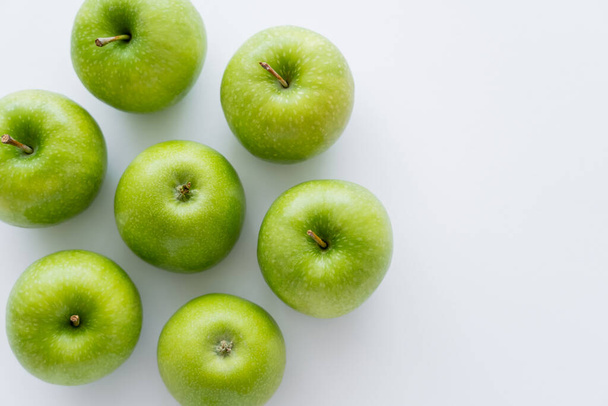 top view of whole green apples on white with copy space - Foto, imagen