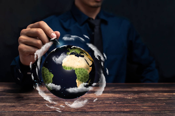man holding a globe on a wooden background - Photo, Image