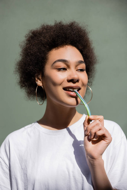 pleased african american woman eating jelly straw  - 写真・画像
