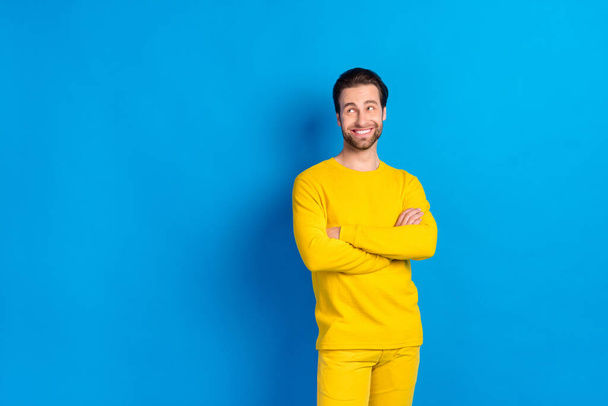 Portrait of attractive cheerful guy wearing pajama folded arms thinking copy space isolated over bright blue color background - Фото, зображення