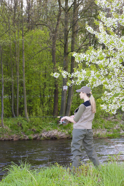 woman fishing by the river in spring - Photo, Image