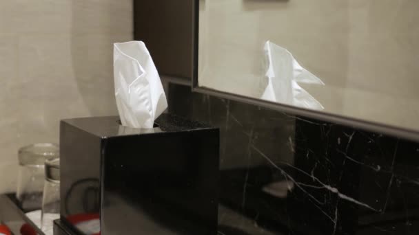 Mit der Hand zieht man weiße Gesichtsgewebe-Serviette aus einer schwarzen Schachtel für sauberes Taschentuch. Gesundheitsmedizinisches Konzept - Filmmaterial, Video