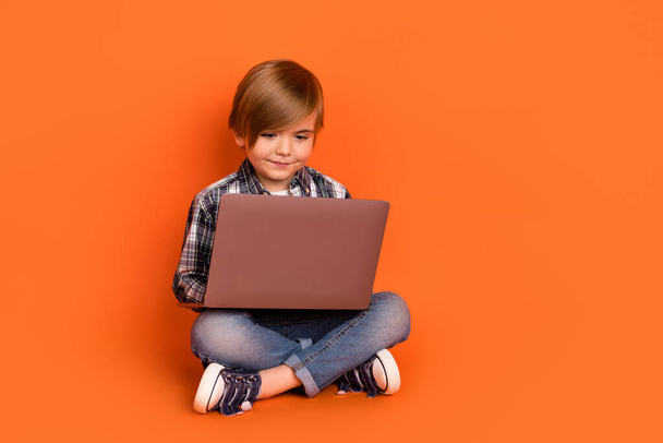 Full length photo of young handsome boy type email homework laptop isolated over orange color background - Фото, изображение