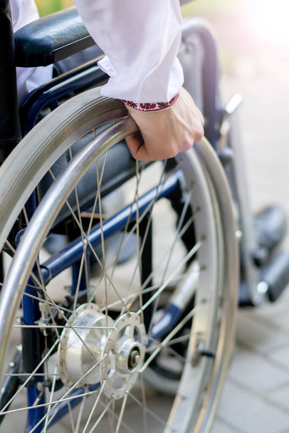 El hombre está discapacitado en una silla de ruedas. cochecito detalles naturaleza. lesión de espalda enfermedad es limitada. accidente de coche. recuperación de rehabilitación después de lesión - Foto, imagen