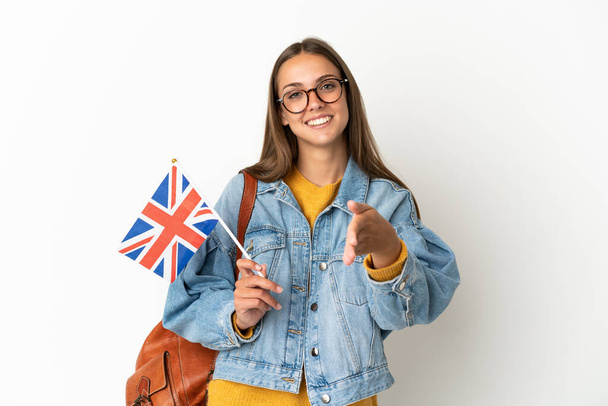 Young hispanic woman holding an United Kingdom flag over isolated white background shaking hands for closing a good deal - Photo, image