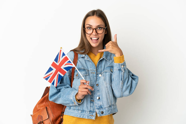 Young hispanic woman holding an United Kingdom flag over isolated white background making phone gesture. Call me back sign - Foto, Bild