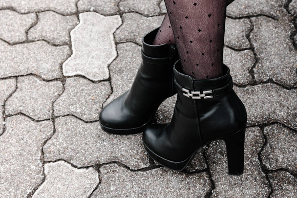 dámské nohy s nylonkami a vysoké černé boty s výhledem z boku - Fotografie, Obrázek