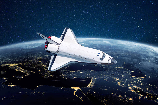 Space shuttle razzo vola sopra il pianeta blu terra con le luci della città sullo sfondo di stelle. Nave spaziale lanciata nello spazio avviare una missione ed esplorare nuovi pianeti - Foto, immagini