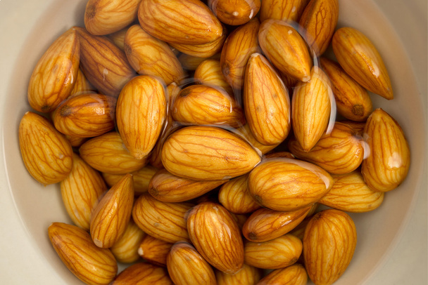 Closeup of almonds soaked in water - Photo, Image