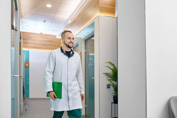 Médecin souriant marchant dans le couloir de l'hôpital - Photo, image