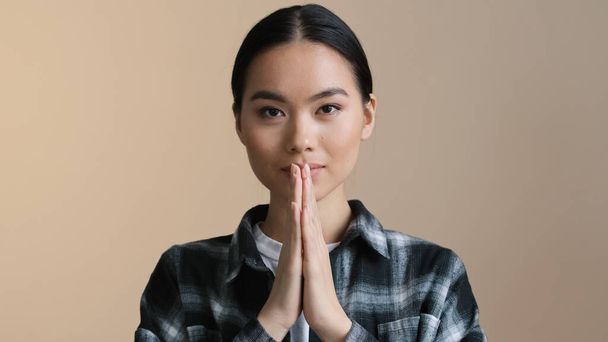 Close up portrait asian calm girl folds palms in front bows namaste greeting prays. Korean japanese lady chinese woman asking for forgiveness apology gesture hope spiritual praying with folding hands - Photo, Image