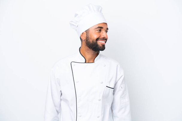 Joven chef brasileño aislado sobre fondo blanco mirando lado - Foto, Imagen