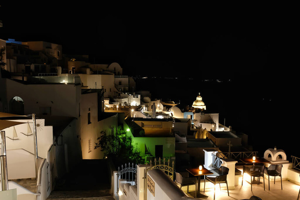 Vista panorámica del pueblo iluminado de Fira Santorini por la noche - Foto, Imagen