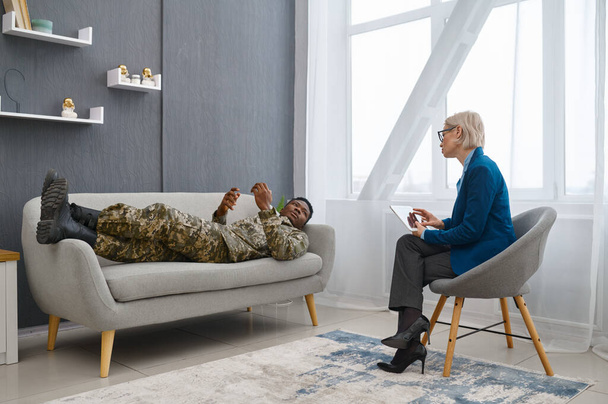 Психолог робить нотатки під час розмови солдата-чоловіка
 - Фото, зображення