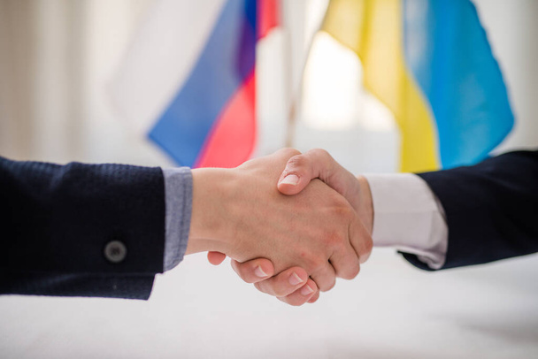 Representatives of Ukraine and Russia shaking hands, Ukraine peace agreement concept. - Photo, image