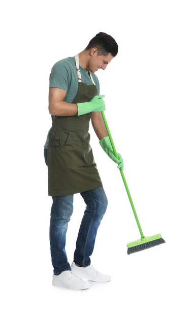 Man with green broom on white background - Фото, изображение