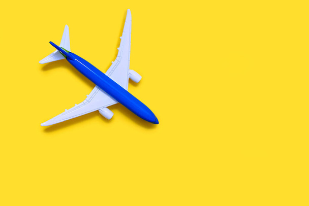 Airplane model on a yellow background with free space for text or advertising. Tourism or freight transport concept. Toy airplane on a yellow background with a top view - Foto, Imagen