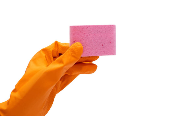 Oranje rubberen handschoen en roze washandje op een witte achtergrond. Reiniging van het terrein en afwassen met behulp van producten in de vorm van een rubberen handschoen en een washandje voor het wassen - Foto, afbeelding