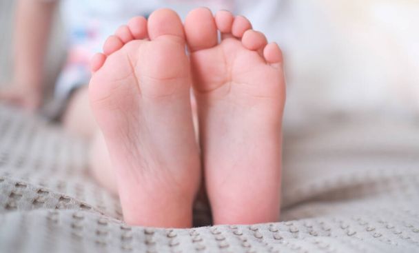 Close-up van kinderbenen met voeten naar voren - Foto, afbeelding