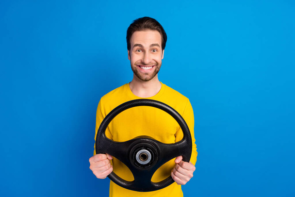 Portrait of attractive cheerful brunet guy holding steering wheel road way isolated over bright blue color background - Photo, Image