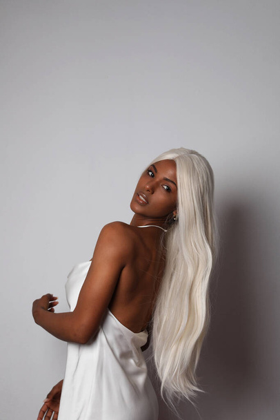 Portrait of African American young woman with long blond hair. Vertical. - Foto, imagen