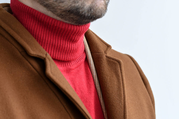 Detail of men outwear, fashionable mens brown coat combined with red sweater and light beige blazer. Selective focus. - Photo, Image