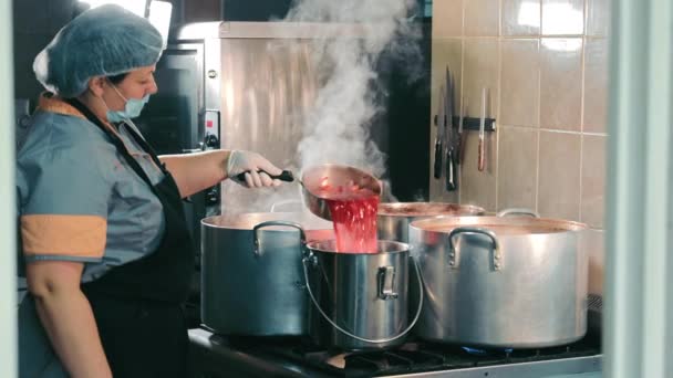 Koken voor mensen met een laag inkomen. Chef-kok vrouw koken in aluminium container. Rode soep voor de armen. - Video