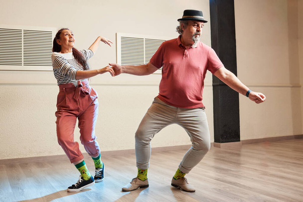 Un homme et une femme dansent Lindy Hop dans un studio de danse - Photo, image