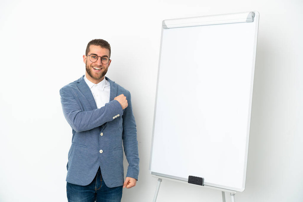 Young business woman giving a presentation on white board isolated on white background celebrating a victory - Foto, Imagem