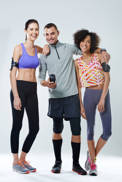 My workout buddies. Portrait of three young adults wearing sports clothing in studio. - Foto, afbeelding