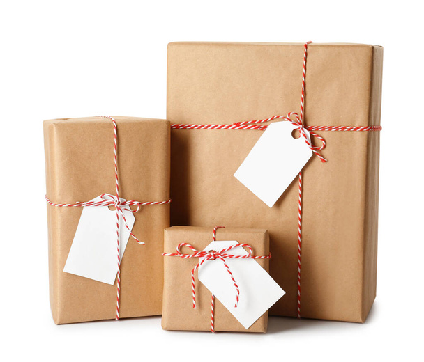 Gift boxes wrapped in kraft paper with tags on white background - Fotó, kép