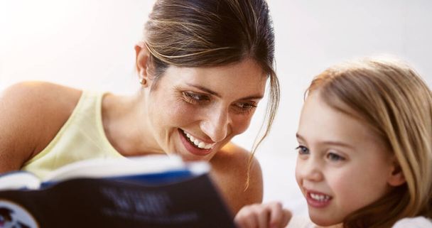 Kitaplara karşı benzer bir sevgimiz var. Genç ve güzel bir annenin evde kızıyla kitap okuduğu bir fotoğraf.. - Fotoğraf, Görsel
