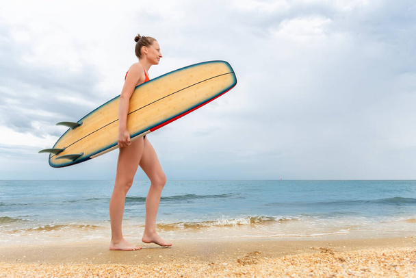 Side profile view young adult slim sporty female surfer girl enjoy having fun swimming surfboard ocean coast wave clear water sunny day. Sport healthy carefree hobby lifestyle vacation concept - Valokuva, kuva
