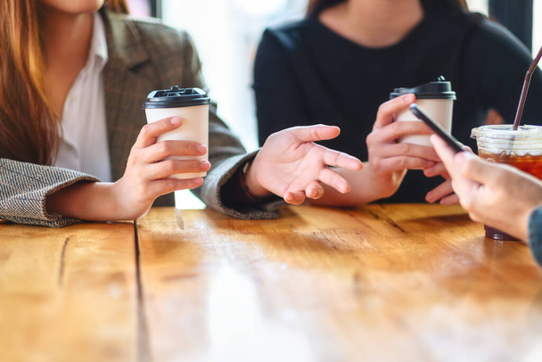 Szoros kép a mobiltelefont használó és együtt kávézó emberekről - Fotó, kép