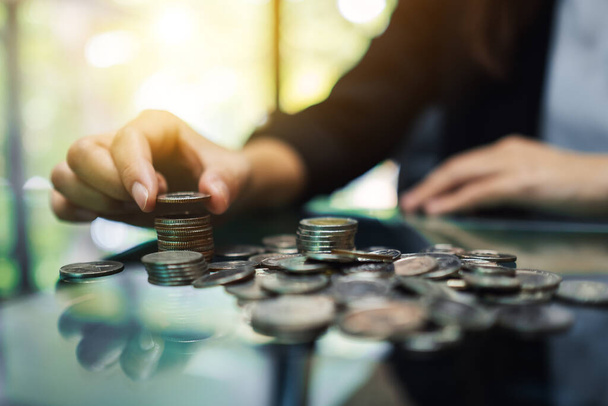 Empresaria contando y apilando monedas sobre la mesa para ahorrar dinero y concepto financiero - Foto, imagen
