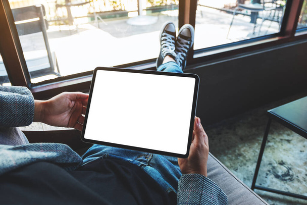 Mockup image of a woman holding black tablet pc with blank white desktop screen - Foto, afbeelding