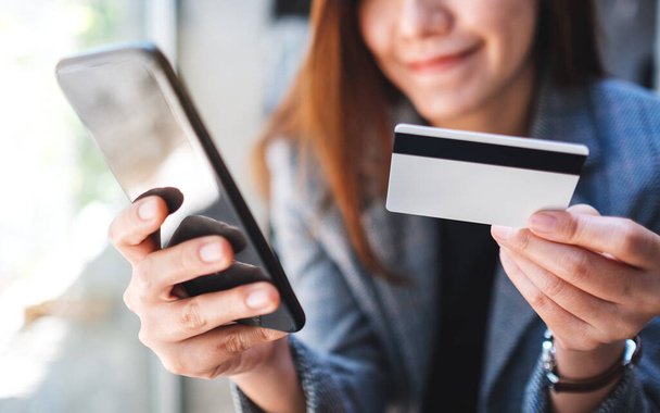 Krásná asijská žena pomocí kreditní karty pro nákup a nakupování online na mobilním telefonu - Fotografie, Obrázek