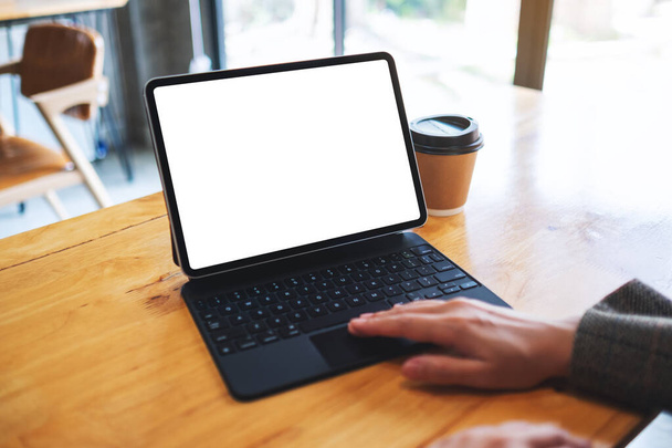 Макет зображення бізнес-леді, що використовує і торкається планшетної тачпадки з порожнім білим екраном стільниці як комп'ютерний ПК з чашкою кави на столі
 - Фото, зображення
