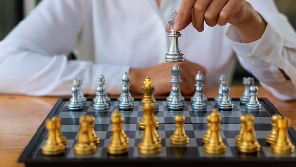 Handschach kann in der Planung des Wettbewerbs in der Wirtschaft interpretiert werden Eine Ecke des Schachbretts im Fokus, auf einem Holztisch. - Foto, Bild