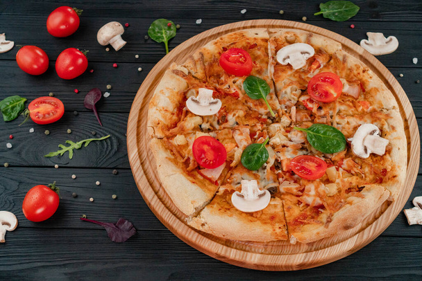 Pizza mit Mozzarella-Käse, Pilzen, Tomaten, Kräutern und Pfefferoni-Gewürzen. - Foto, Bild