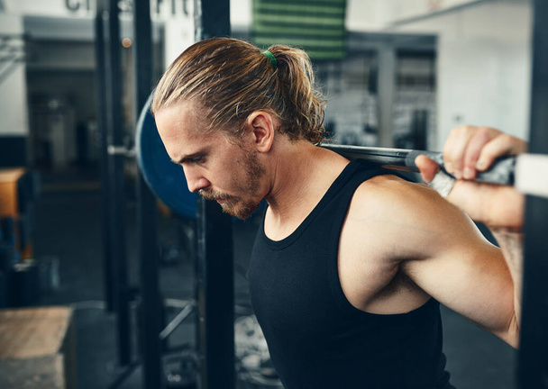 Stop existing and start lifting. Shot of a man lifting weights at the gym. - Valokuva, kuva