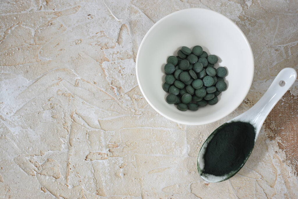 Una cucharada de algas verdes en polvo, pastillas y cápsulas - Foto, imagen
