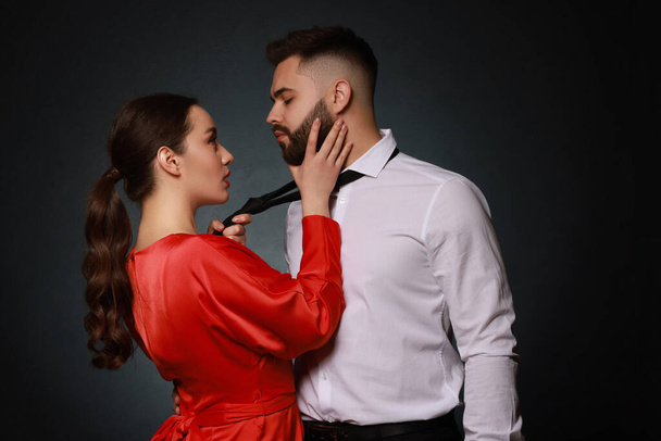 Handsome bearded man with sexy lady on dark background - Foto, Imagen