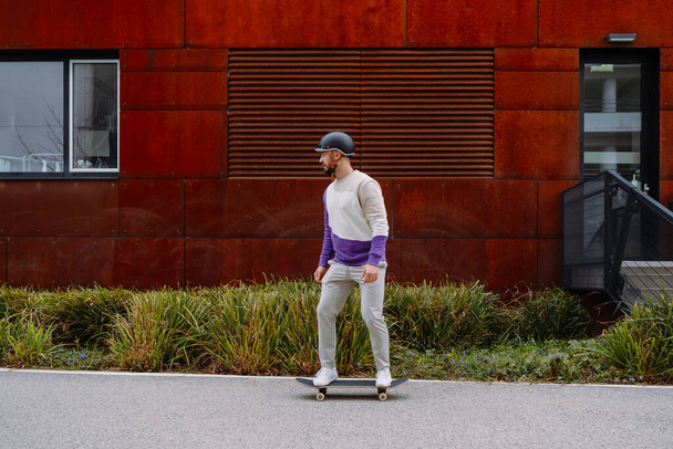 Portrét mladého krasavce se skateboardem. Městské průmyslové zázemí - Fotografie, Obrázek